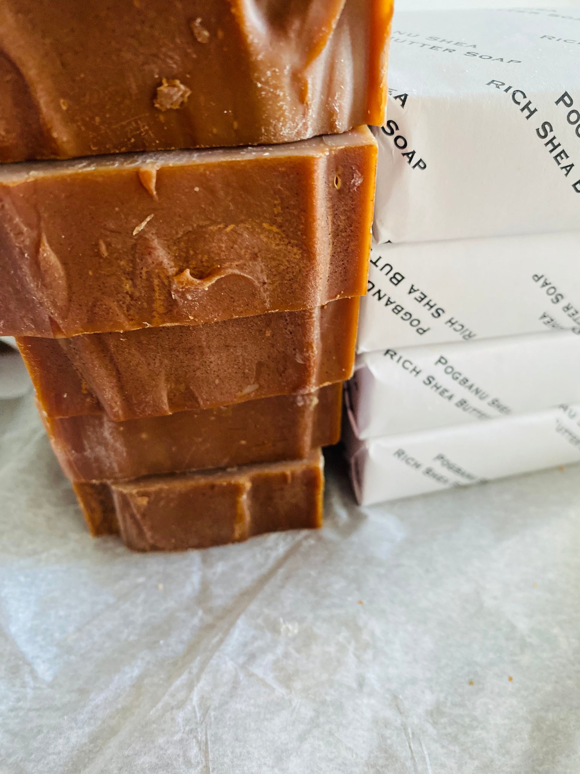 Stack of brown soap bars with white packaging in the background